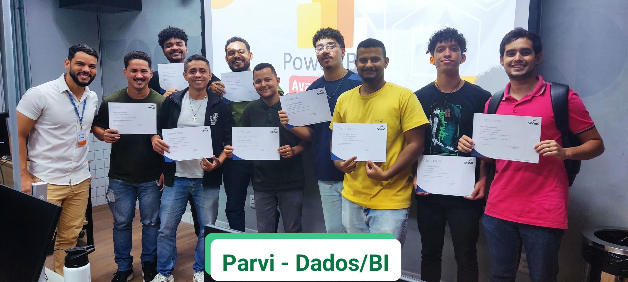 Turma de alunos formados segurando certificados em formação de Dados e BI
